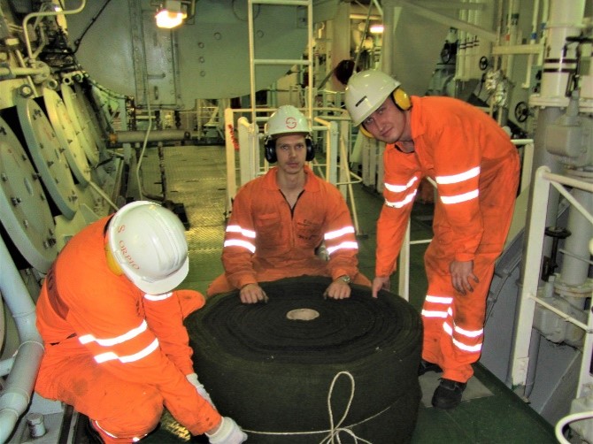 Three seafarers working on a vessel.