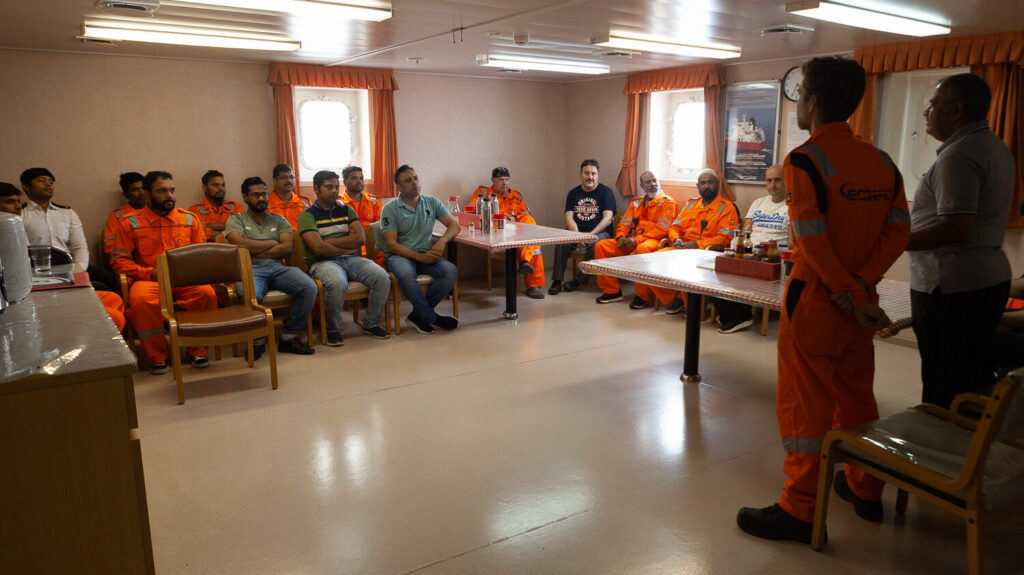 Crew onboard a vessel sitting around for a training seminar.